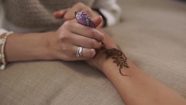 Artista está desenhando padrões mehndi em mãos de mulher, close-up — Vídeo de Stock