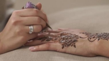Shot kadının el kadar güzel mehndi sanat deri üzerinde yapıyor bir kına koni ile kapatın. Parmaklar üzerinde çizim. Güzel çiçekler.