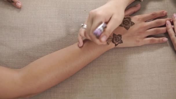 Женщина делает боди-арт за хной на руках девушки, крупным планом сверху — стоковое видео