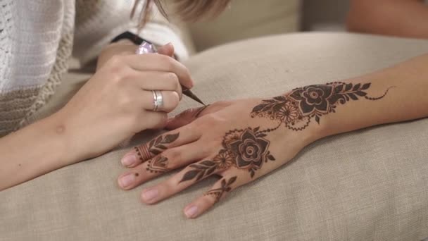 Frau zeichnet mehndi Designs auf die Hände ihres Freundes Mädchen, Nahaufnahme — Stockvideo