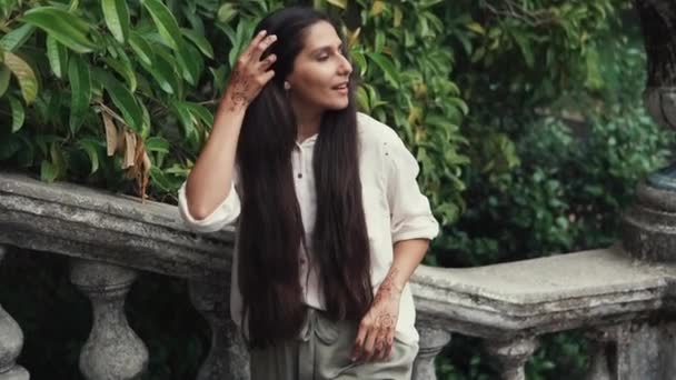 Mladá dlouhé vlasy žena odpočívá šikmou na schodech v parku — Stock video