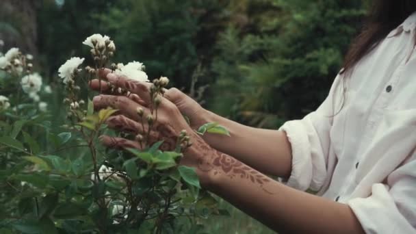 触れると森の野生の花を楽しんでいる女性のショットを閉じる 自然の屋外エキゾチックな白い花を持つ女性 ヘナのアート — ストック動画