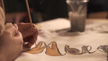 Boya fırçası ile el Close-up bir atölye beyaz gömlek boyama
