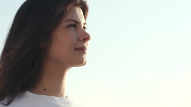 Retrato de mulher bonita olhando para a frente inspirado contra o céu claro — Vídeo de Stock