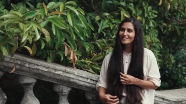 Esmer gülümseyen bir bahçede yalnız duruyor