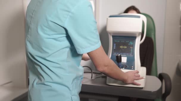 Oculista está imprimiendo los resultados de inspeccionar los ojos desde el refractómetro automático en la oficina — Vídeos de Stock