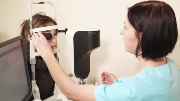 Портрет врача, который устанавливает аппарат для биомикроскопии сетчатки глаза — стоковое видео