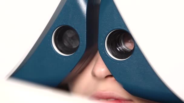 Face of patient in a phoropter, changing lenses for measuring refractive error — Stock Video