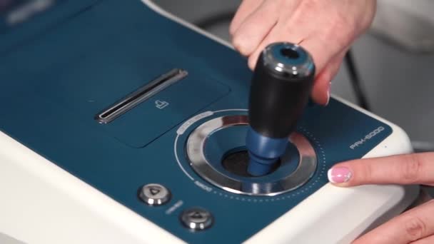 Tiro de perto dos dedos médicos ele segura joystick do autorefratômetro — Vídeo de Stock