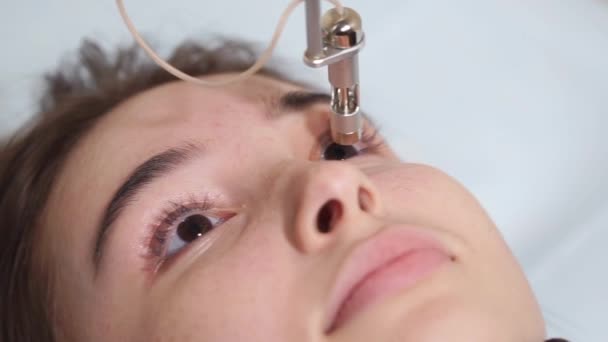 Mulher jovem está deitada em um armário durante a operação de correção a laser da visão — Vídeo de Stock