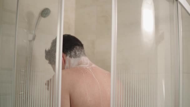 Ο άνθρωπος χρησιμοποιώντας σαμπουάν στο ντους. — Αρχείο Βίντεο