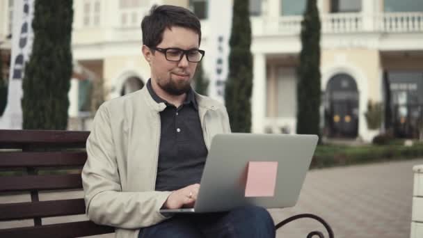 Smiling freelancer with laptop outdoor. — Stock Video