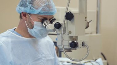 İçinde mikroskop işlemi sırasında bakarak konsantre erkek doktor yüzü