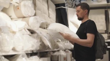 Genç adam için bir salonu, rüyada yastık bağımsız olarak seçme çalışıyor