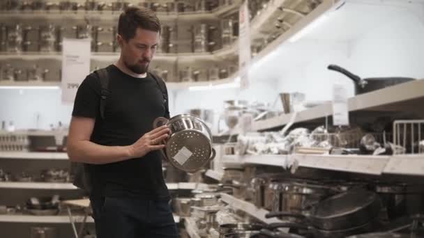 Bebaarde man is vergiet in handen houden en draaien, staan in de winkel — Stockvideo