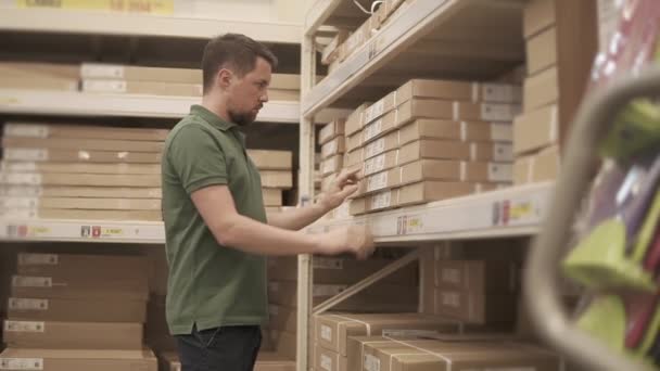 Shopper is looking for a necessary good in a warehouse of building shop — Stock Video