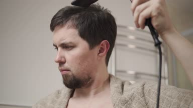 Sakallı adam saç yıkama kafa sonra saç kurutma makinesi, yakın çekim kullanarak kurutma