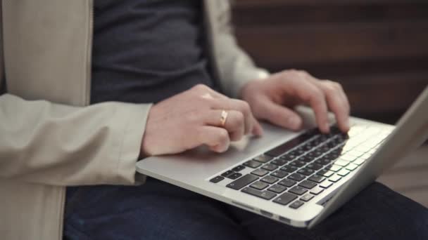 Крупный план клавиатуры и сенсорной панели ноутбука и мужских рук во время работы — стоковое видео