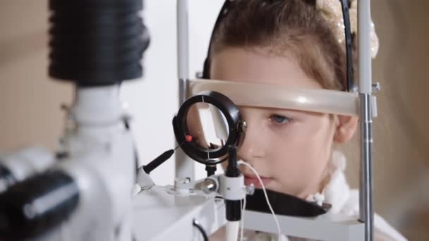 Маленькая девочка на глазной биомикроскопии — стоковое видео