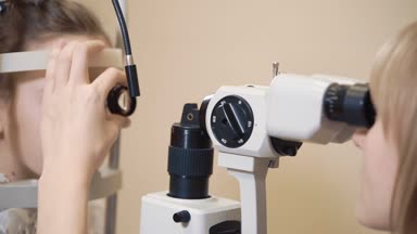 Doktor çocuğun gözleri kontrol etmek için göz Biomicroscopy içinde nişanlandı