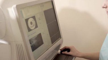 Doktor retina tomografisi aygıtın arkasında oturuyor