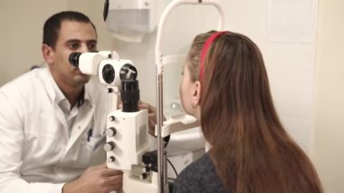 bir genç vizyonunu kontrol etmek için bir göz kliniği bir kaide üzerinde kafa giderir