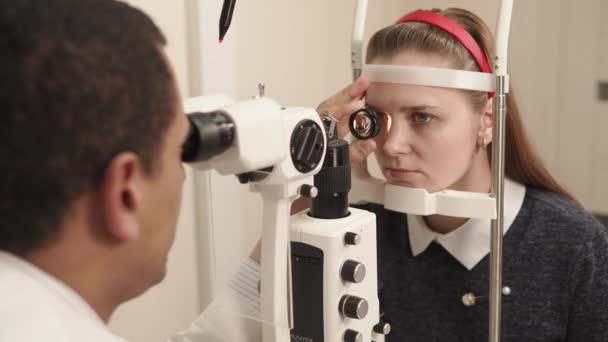 Oculista lavora in policlinico, l'uomo usa il dispositivo per biomicroscopia di un occhio — Video Stock