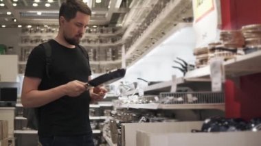 Genç bir adam bir tava içinde belgili tanımlık stok üstünde yemek için seçer