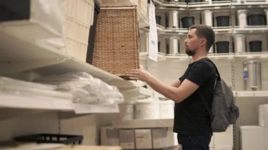 Yetişkin bir adam kirli çamaşır konteynerler dikkate alır, o bir alışveriş merkezinde