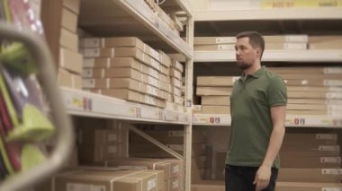 Genç bir adam alışveriş merkezinde ve kutuyu depodan alır