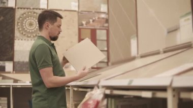 Onun ellerinde branda parçası tutan bir adam, o onarımları yapmak istiyor