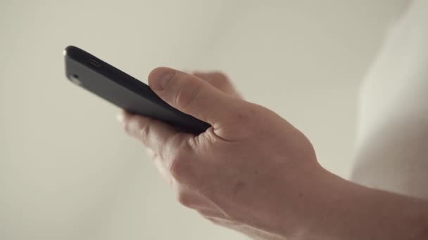 plan rapproché d'un mans mains, qui envoie un message sur un téléphone mobile 