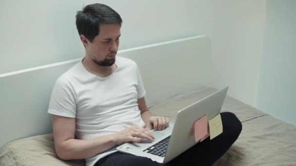 Homem trabalha como escritor e imprime o texto de um novo livro em um laptop — Vídeo de Stock