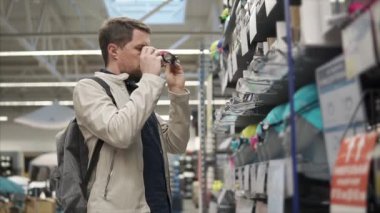 Genç adam çalışıyor bir yüzme sporu için malların büyük bir mağazada koruyucu gözlük