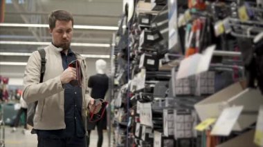 Yetişkin adam eğitim bir spor mağazası için bir el spor simülatörü incelenmesi