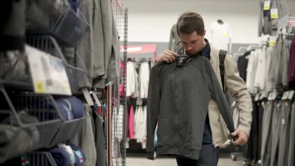 Mužů Shopper Drží Závěs Sportovní Mikina Úložišti Ten Zkoumá Kvalitu — Stock video