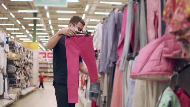 Adult father looking for kids clothes. — Stock Video