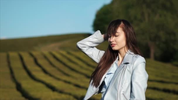 Sensuell brunett flicka vidrör långt hår stående utomhus i sommarkväll — Stockvideo