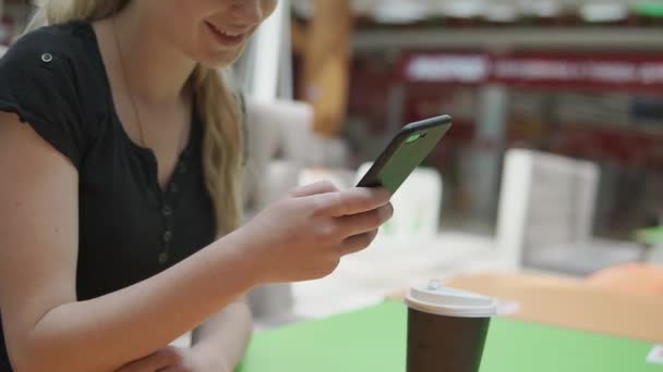 Close-up van vrouwelijke hand met smartphone in de hand achtergrond van café tabel — Stockvideo