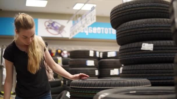 Mujer elige neumáticos para el coche . — Vídeos de Stock