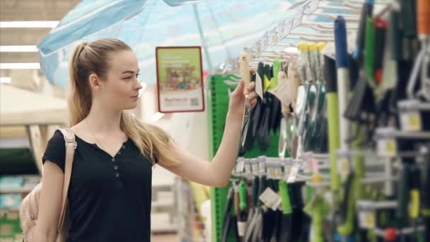 Mladá dívka v obchodě kupovat nástroje. — Stock video