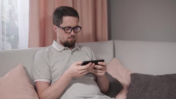 Man using his smartphone at home. — Stock Video