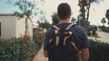 Yalnız adam gün içinde banliyö bölgesinde çalılar arasında yaya yolu üzerinde yürüyor