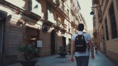Yetişkin adam etrafında bakarak, Avrupa kentinde şehir sokakta yürüyor