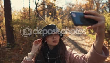 Bir ormanda selfie çeken büyüleyici kız.