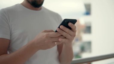 Evli adam el cep telefonu tutarak ve ona bakarak, yakın çekim