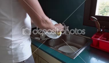 Adam sünger ve su kullanarak plakaları yıkıyor, ellerin yakın çekim