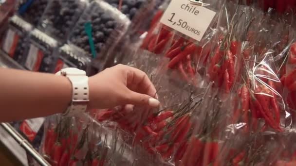 Frau kauft Chilli auf dem Markt. — Stockvideo