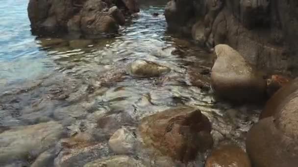 Acqua di mare limpida sta spruzzando su grandi pietre sulla riva, vista da vicino — Video Stock