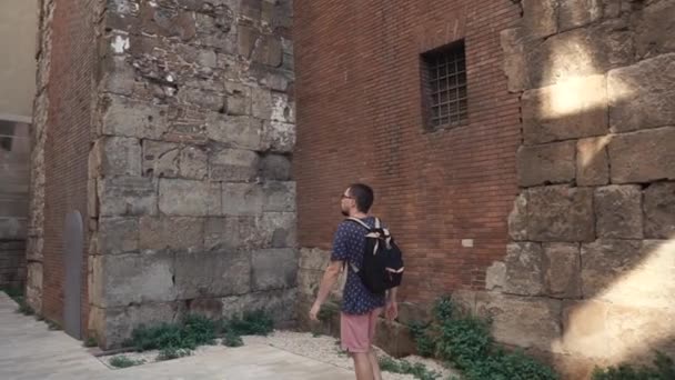 Man in een stad door het oude gebouw. — Stockvideo